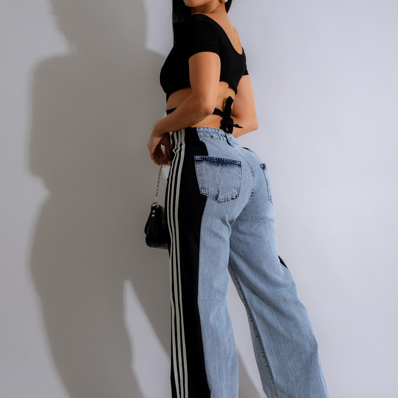 Wide-leg jeans with black athletic stripes, perfect for casual fashion and ملابس styles