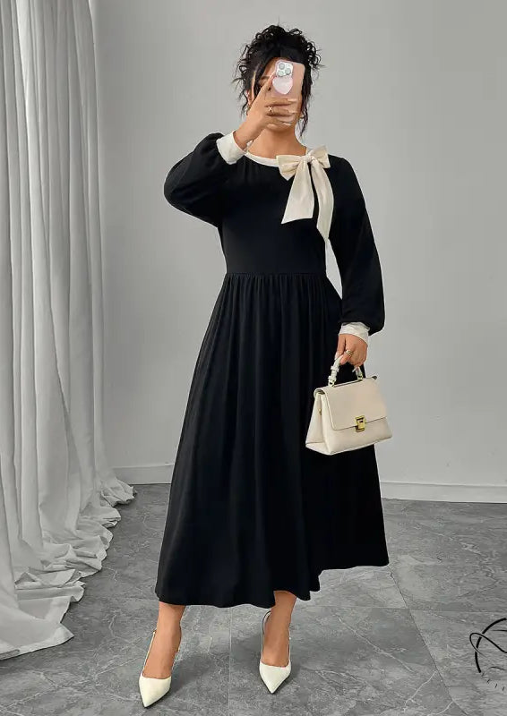 Winter retro slim black dress with long sleeves, white accents, and bow detail