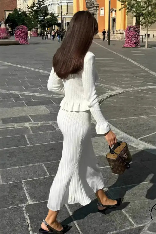 Woman in elegant classic dress and white knitwear with handbag