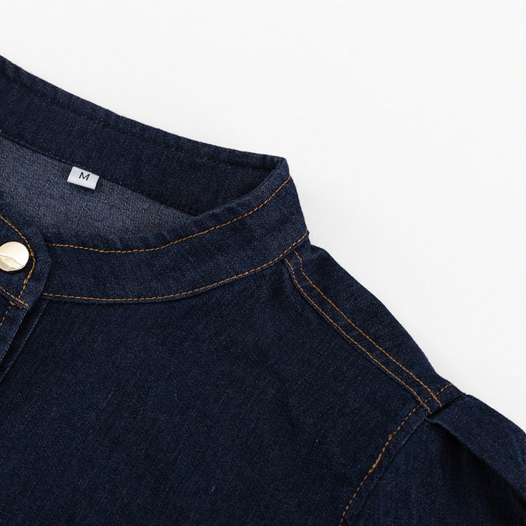 Close-up of a dark blue denim shirt with orange stitching and a gold button, perfect for a fashionable shirt dress
