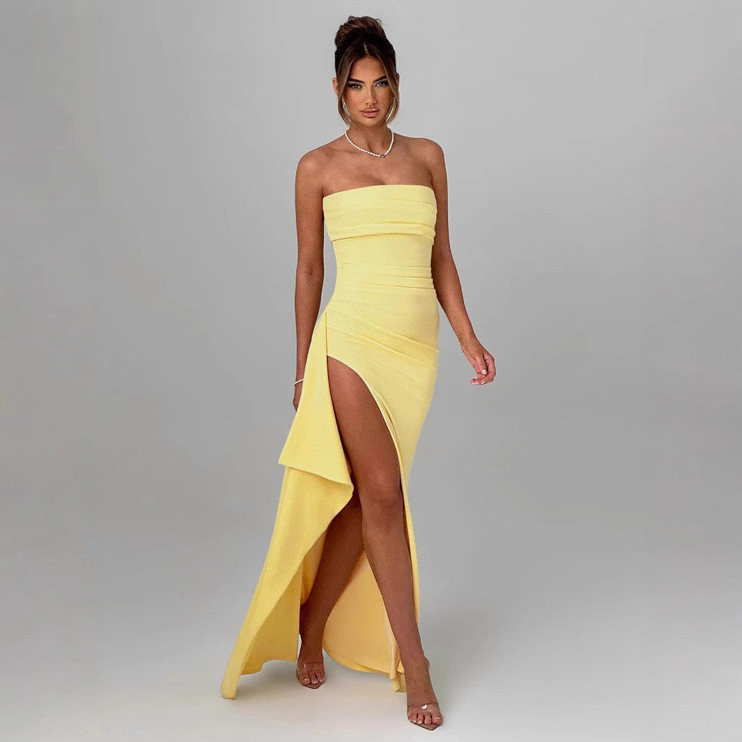 Woman in a yellow strapless dress with a high slit, showcasing elegant fashion ملابس