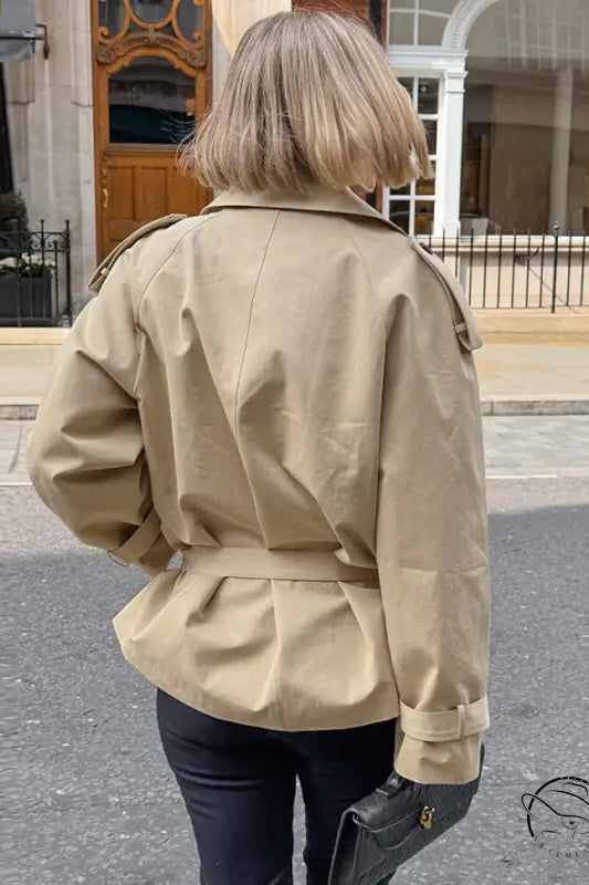 Elegant beige double-breasted trench coat with black buttons, British fashion style