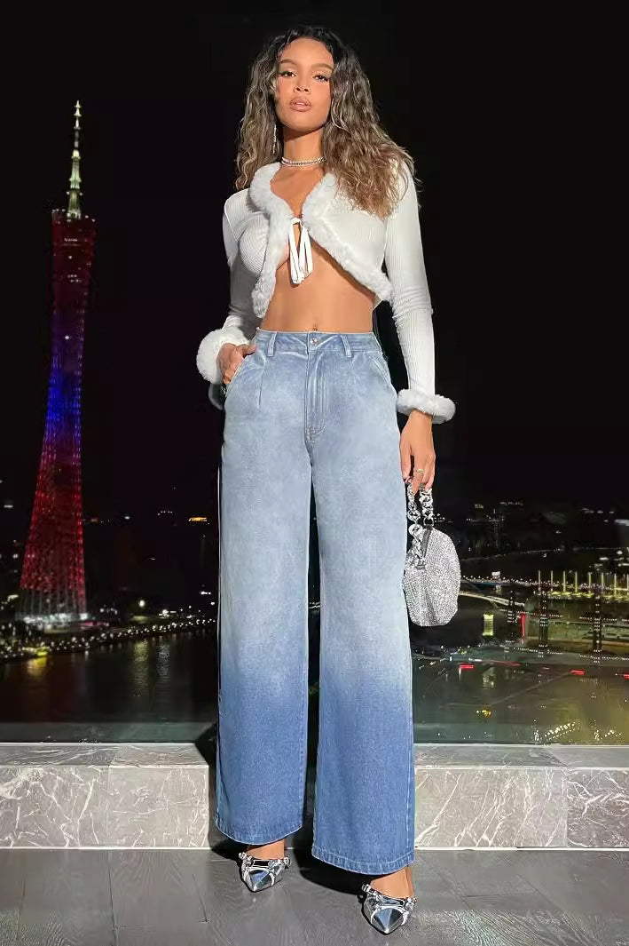 Fashionable woman wearing white cropped top with fur trim and high waist denim trousers