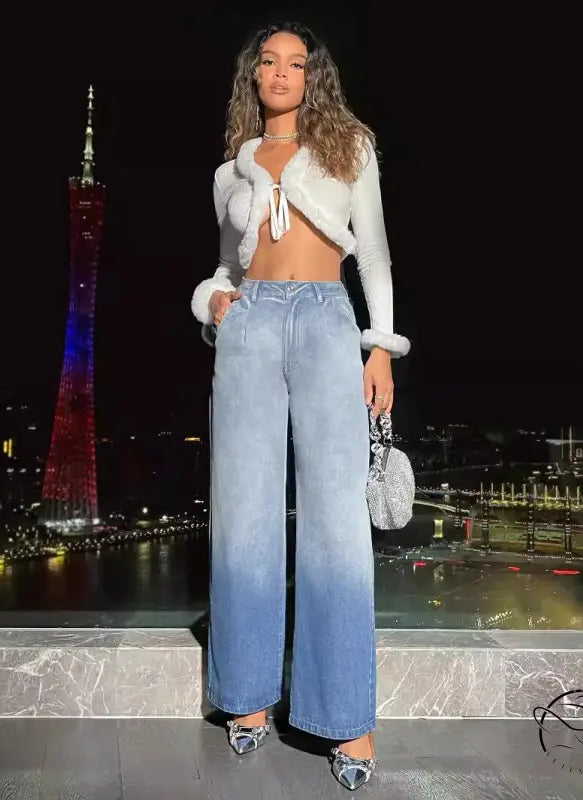 Woman in cropped fur-trim top, light-wash high-waist denim trousers, silver heels