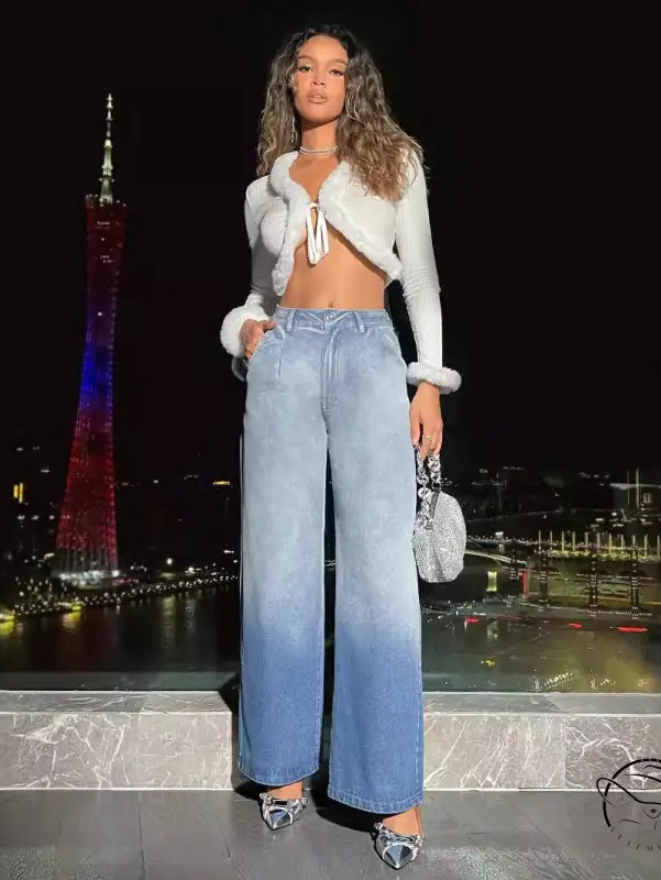 Woman in cropped fur-trim top, light-wash high-waist denim trousers, silver heels