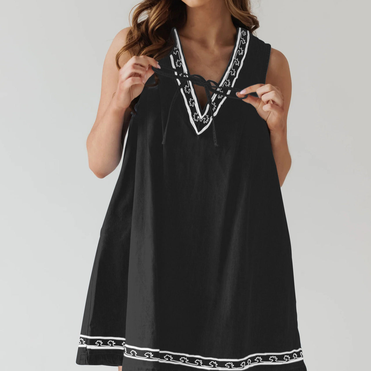Black sleeveless dress with white trim, perfect for stylish ensembles in fashion ملابس