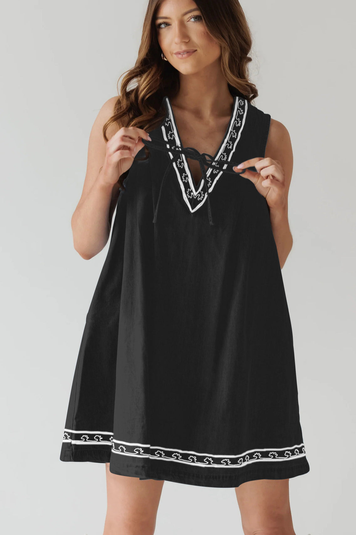 Black sleeveless dress with white trim, perfect for stylish ensembles in fashion ملابس