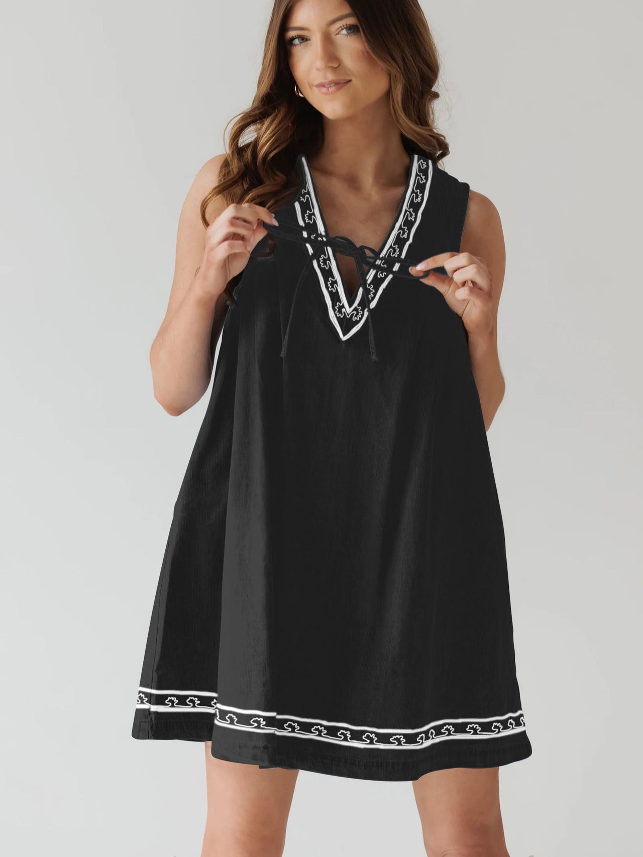 Black sleeveless dress with white trim, perfect for stylish ensembles in fashion ملابس