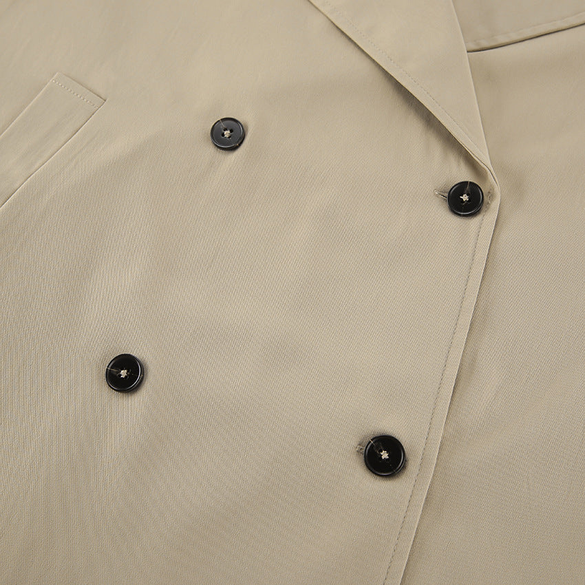 Beige double-breasted trench coat with black buttons and pockets