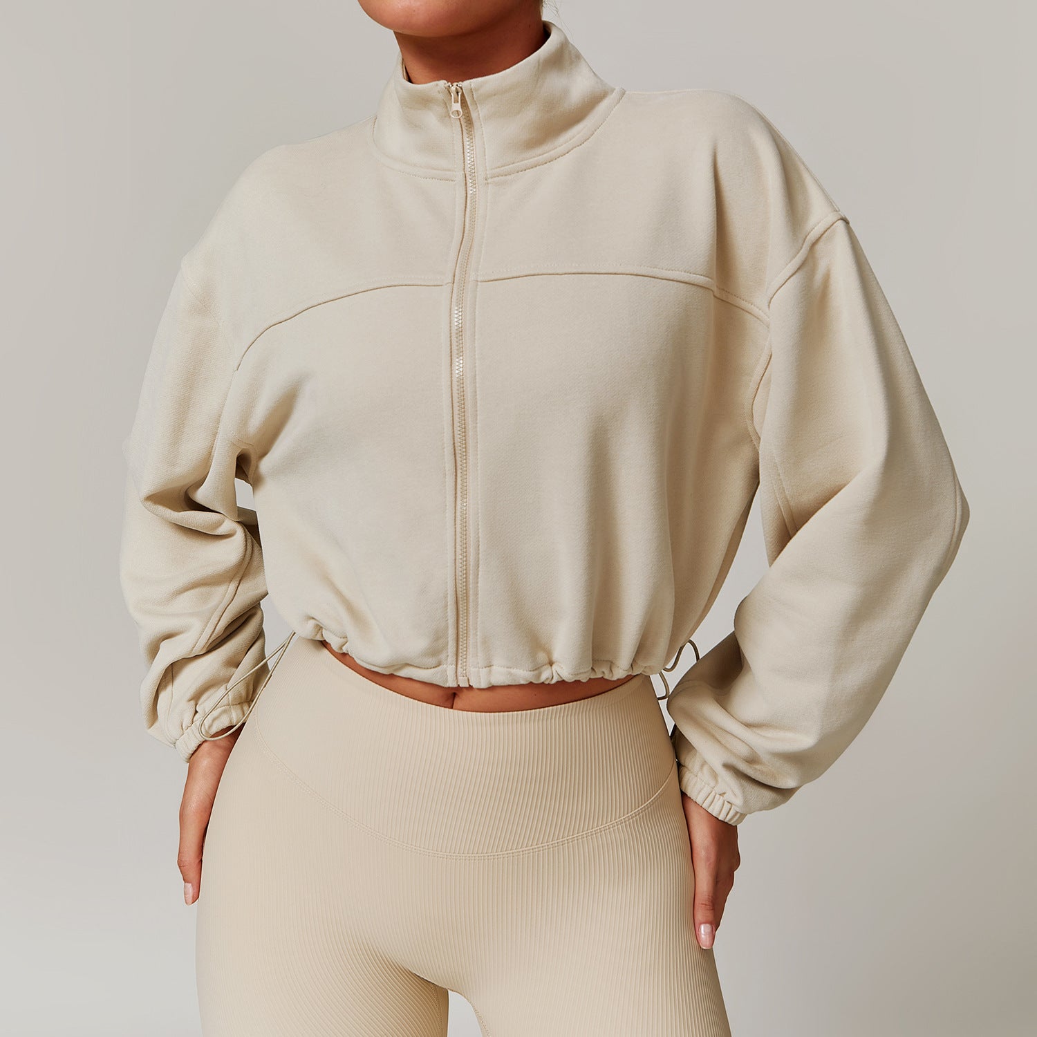 Cream-colored cropped zip-up jacket with balloon sleeves for stylish fall fitness ملابس