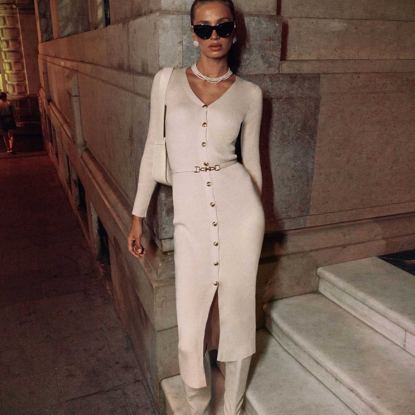 Woman in a long sleeve knitted dress and boots showcasing fashion style