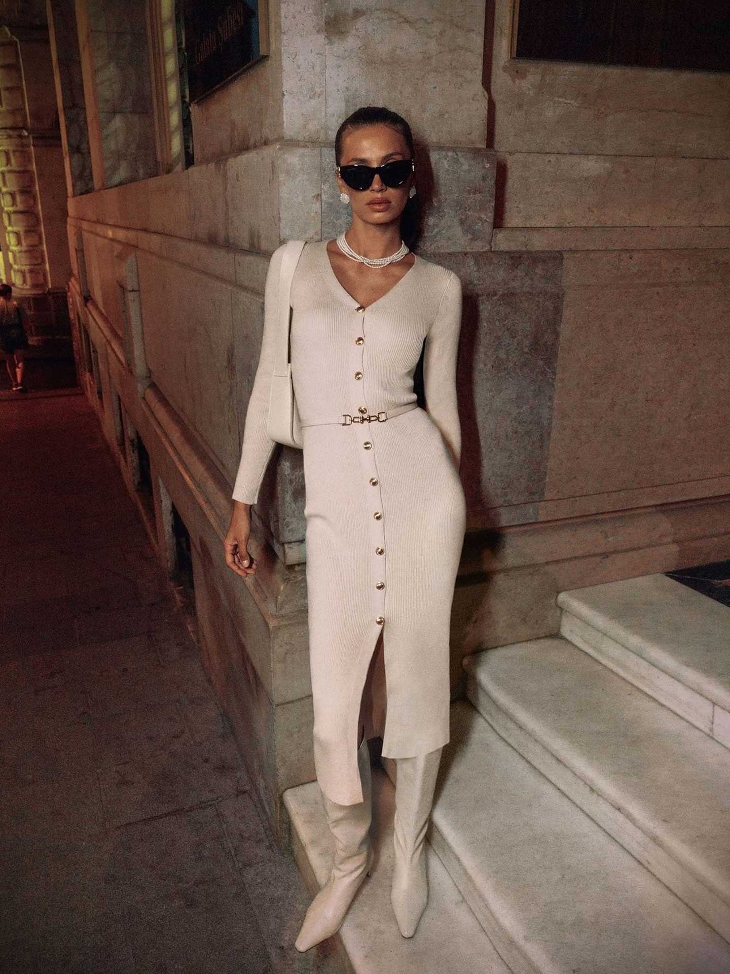 Woman in a long sleeve knitted dress and boots showcasing fashion style