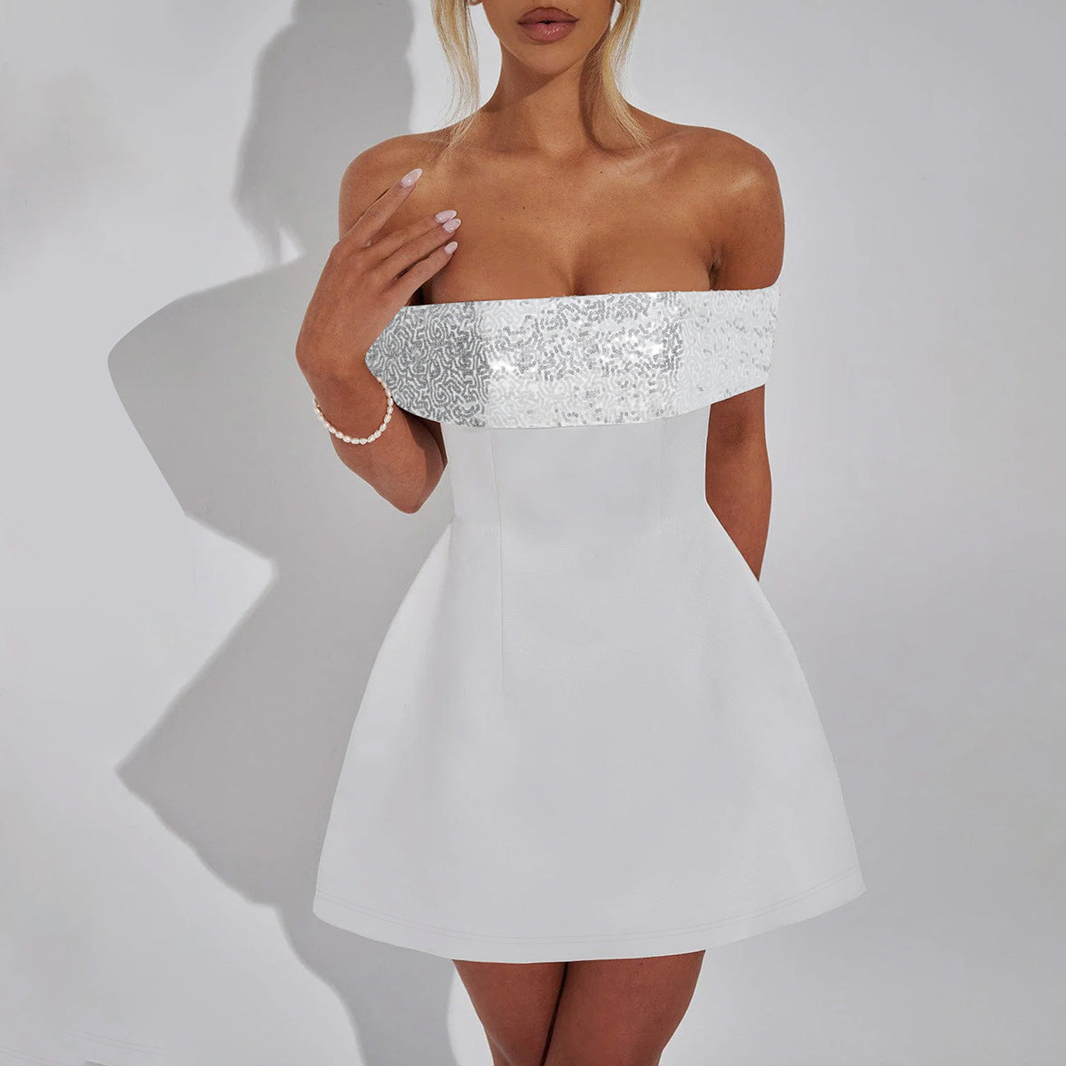 White off-shoulder mini dress with sequined trim, perfect for elegant fashion ملابس