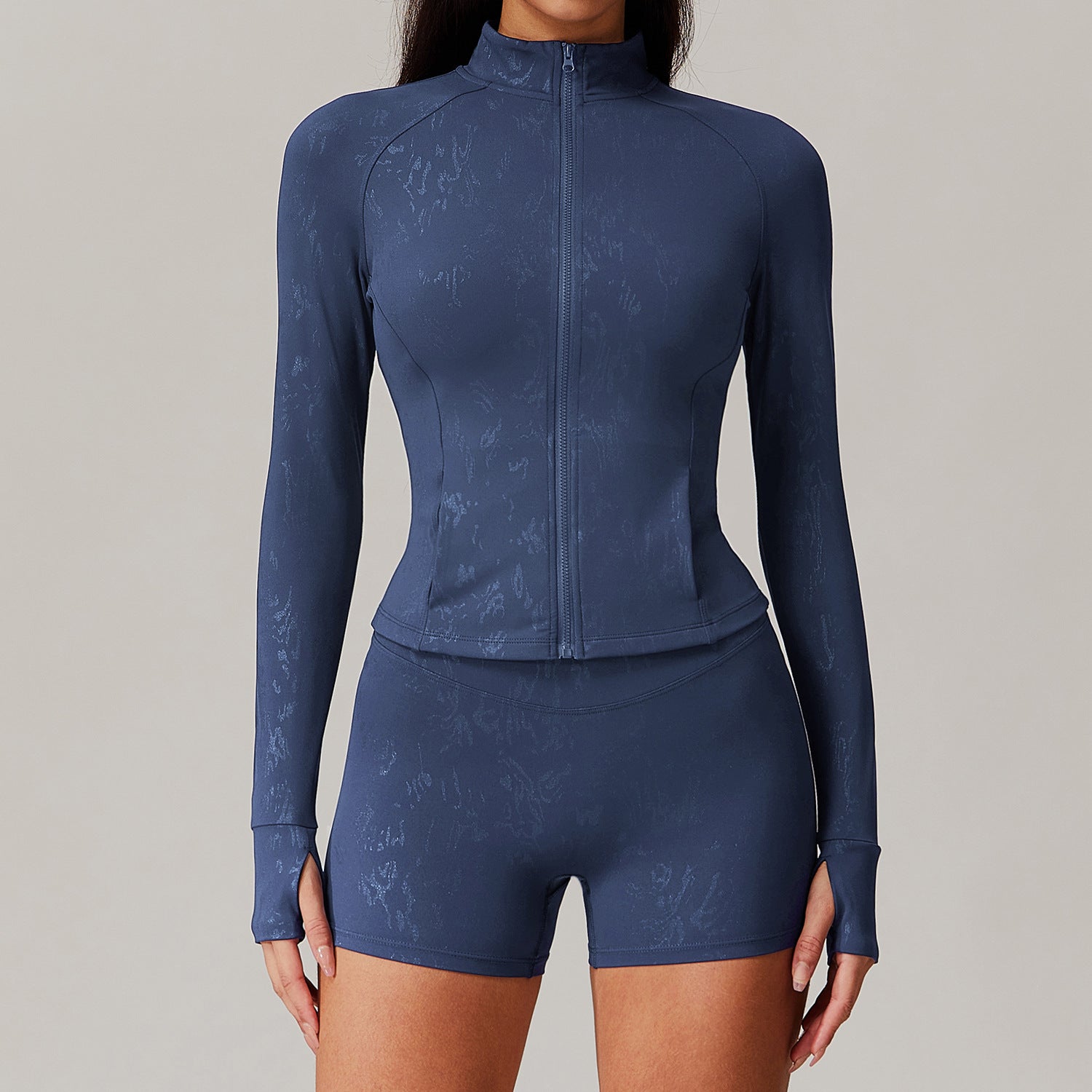 Dark blue women’s activewear set with textured jacket and high-waisted shorts, perfect for yoga and sports fashion
