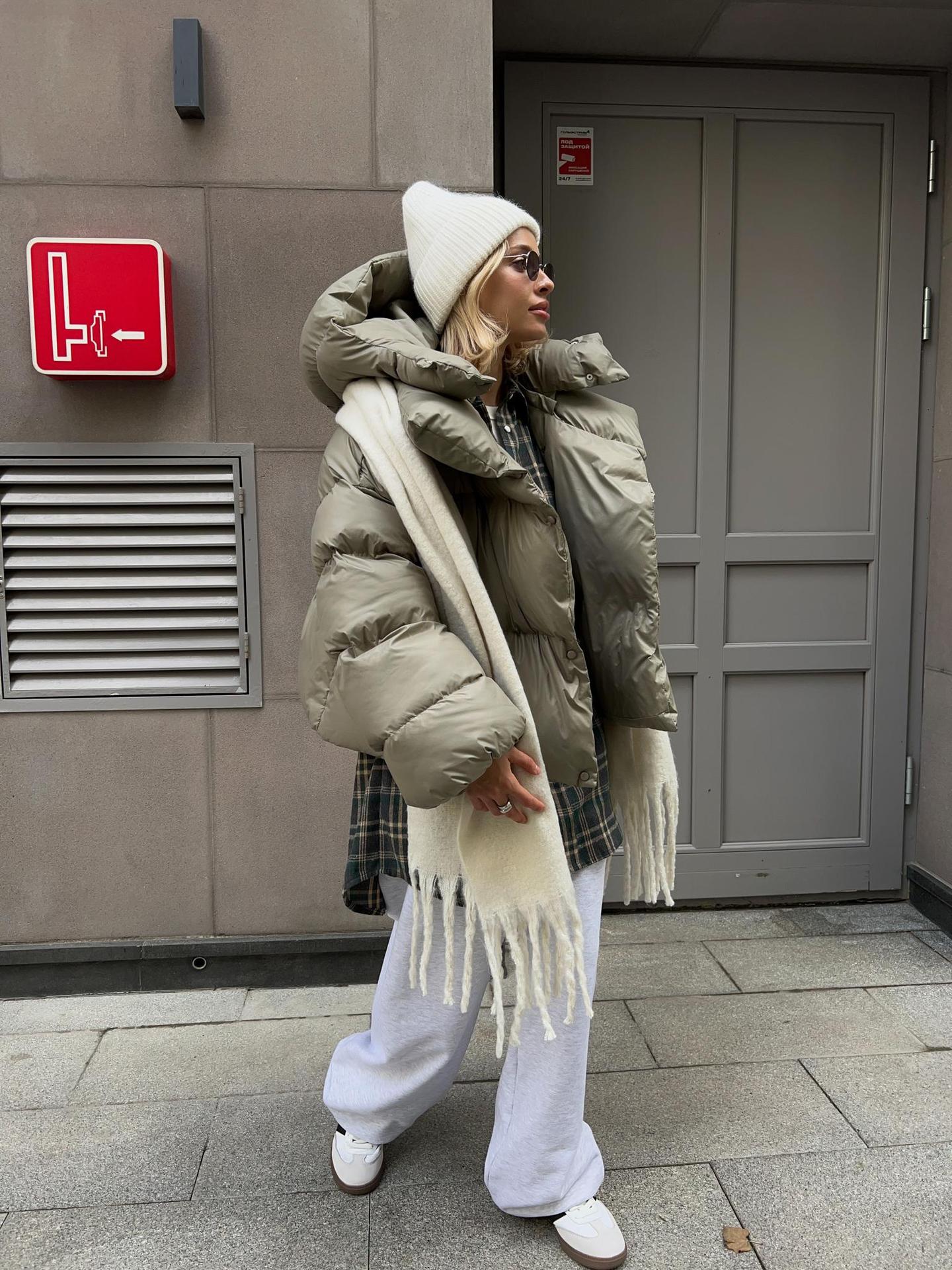 Woman in oversized puffer jacket showcasing fashionable ملابس by Langry