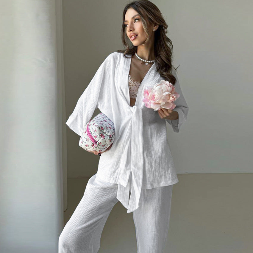 Woman in winter pure cotton pajamas holding floral cosmetic bag and pink flowers