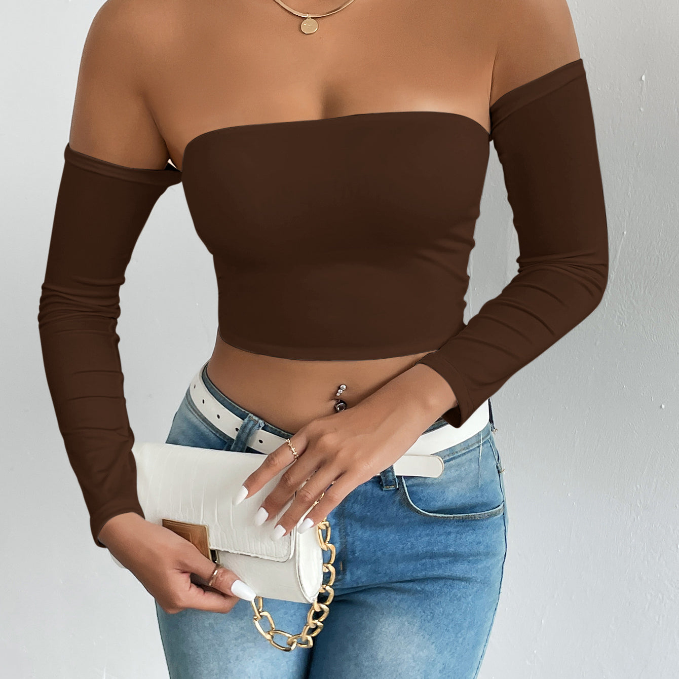 Fashionable brown off-the-shoulder crop top with blue jeans and white accessories