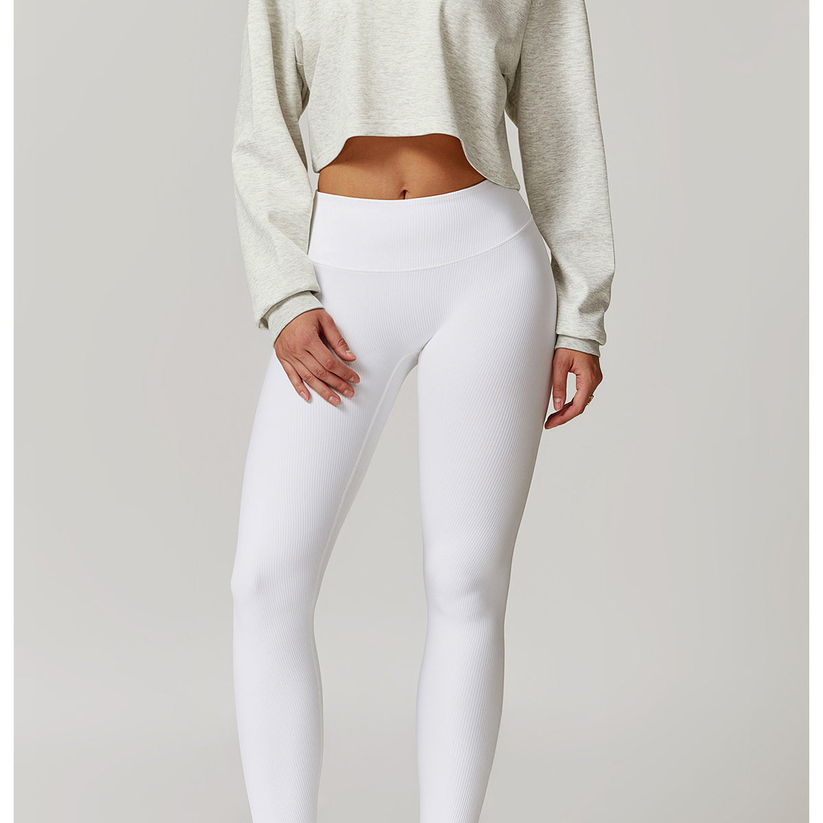 White high-waisted leggings and cropped beige sweater in stylish fashion for Winter Wild Outerwear