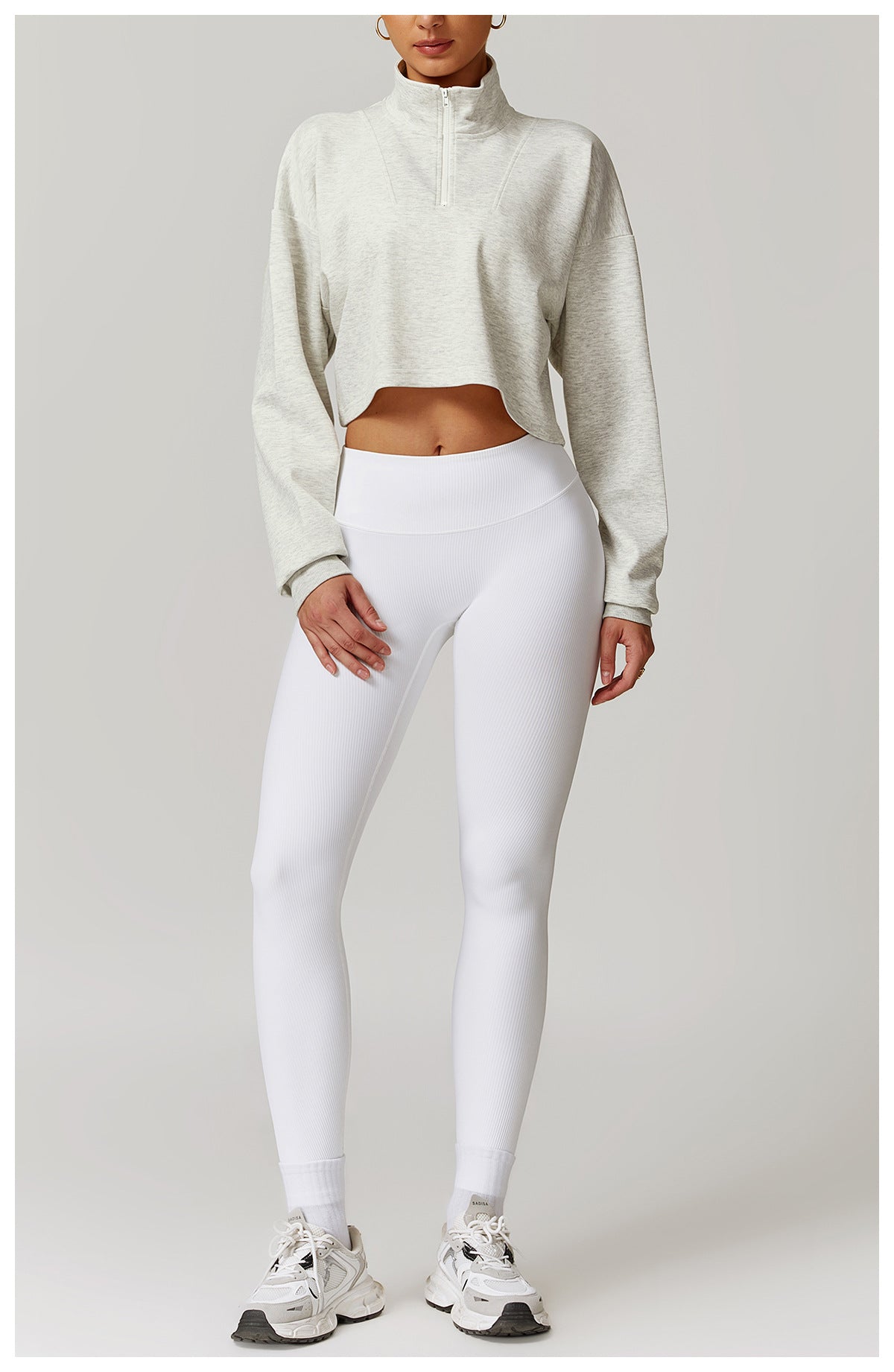 White high-waisted leggings and cropped beige sweater in stylish fashion for Winter Wild Outerwear