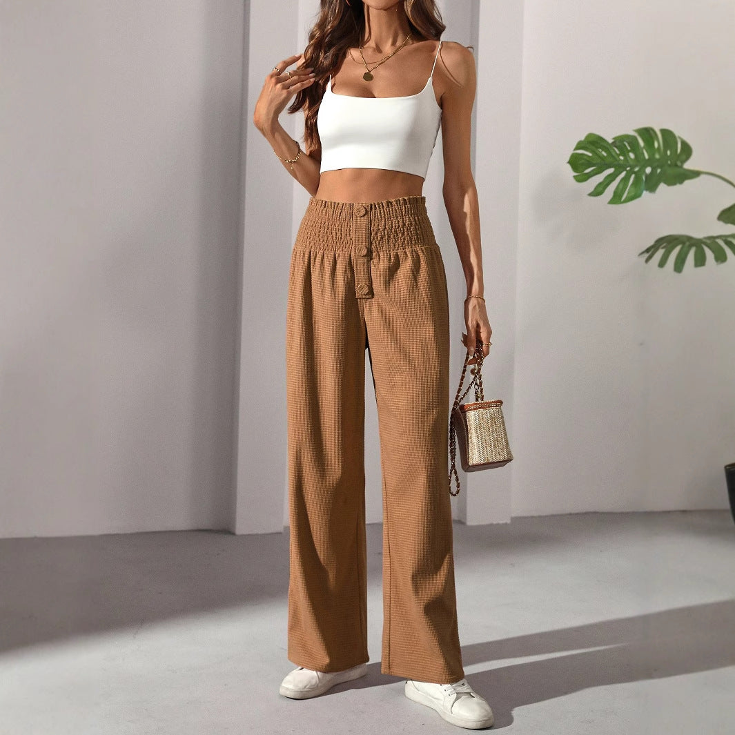 Woman modeling casual elegant French trousers with white crop top and brown high-waisted wide-leg pants