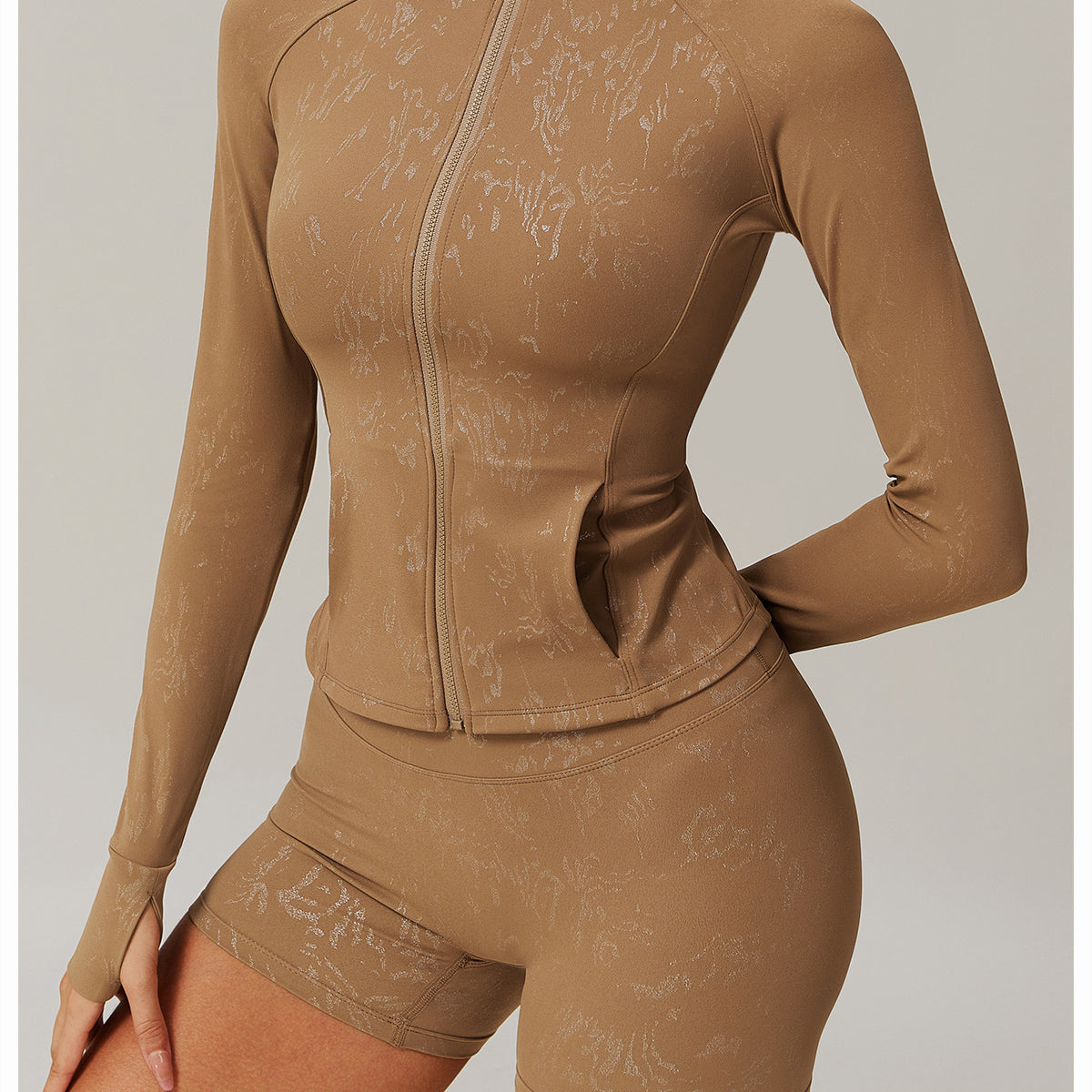 Woman modeling light brown langry fashion full-zip track jacket and biker shorts, ملابس