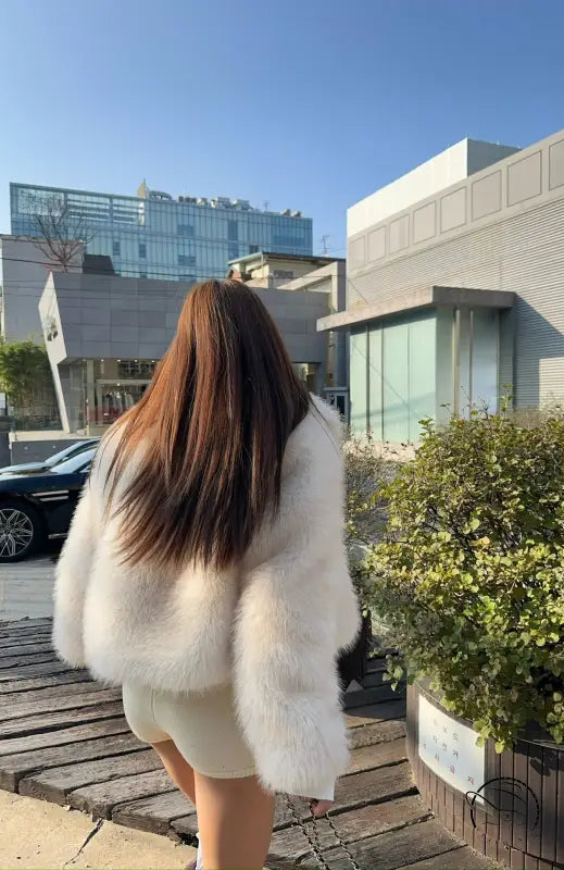 White faux fur coat with long sleeves and high collar