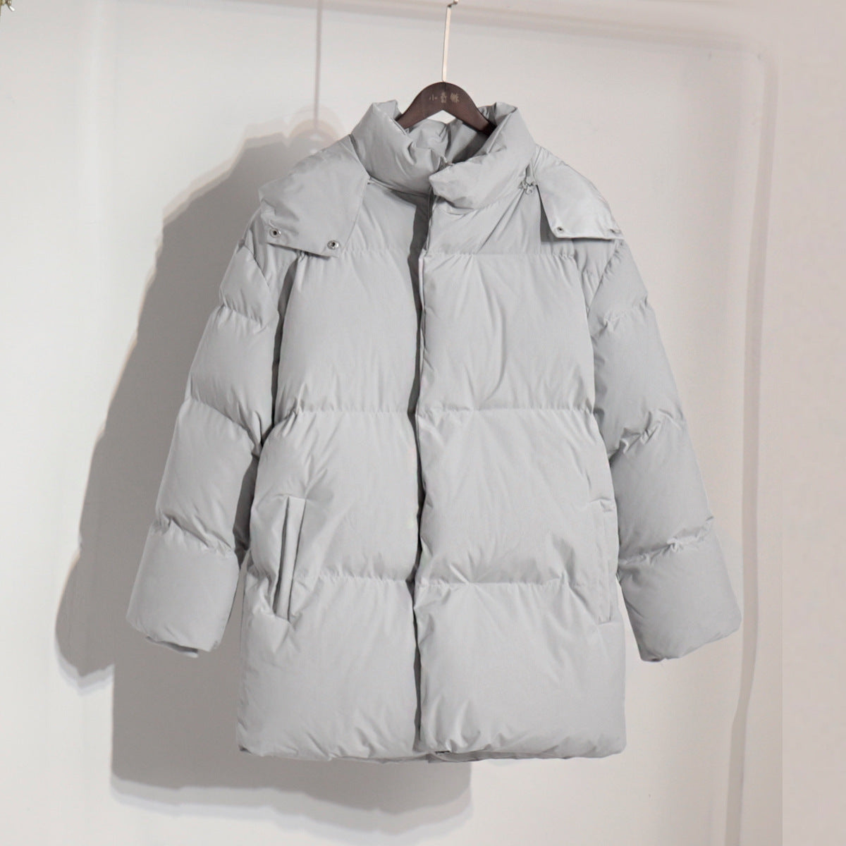 Gray puffer coat on hanger showcasing stylish langry fashion ملابس for winter wear