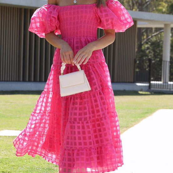 Woman in a pink off-the-shoulder Enchanting Lantern Sleeve Dress, showcasing stylish ملابس