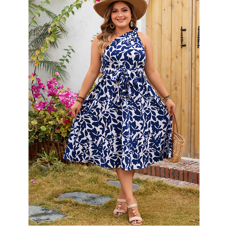 Woman in a blue and white leaf-patterned dress showcasing elegant fashion for ملابس
