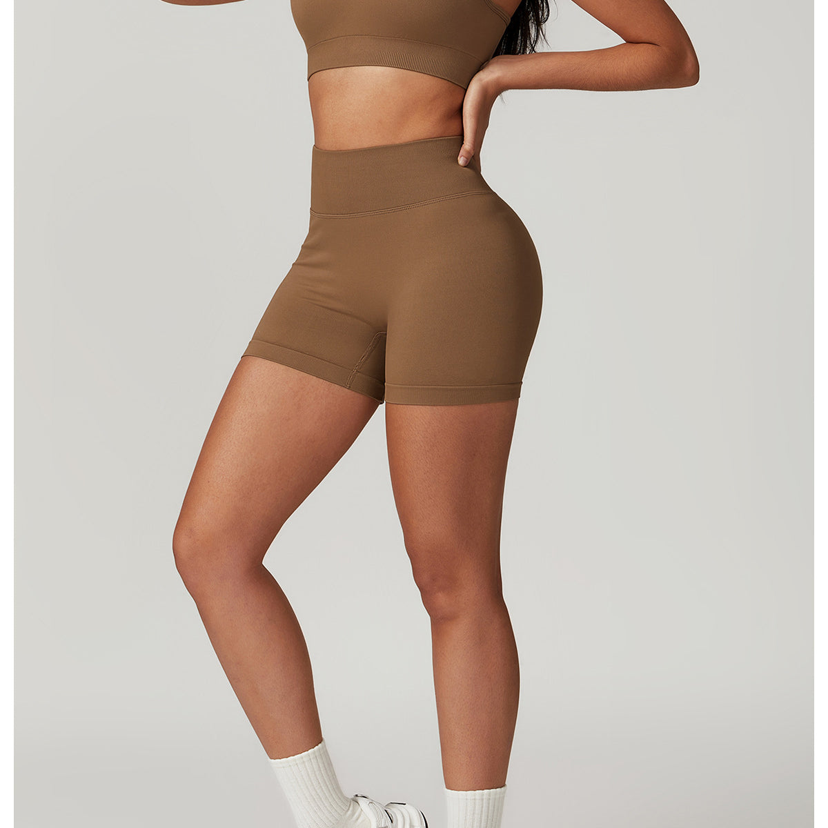 Woman wearing a brown Seamless Yoga Suit, featuring Bra Shorts Rhino design