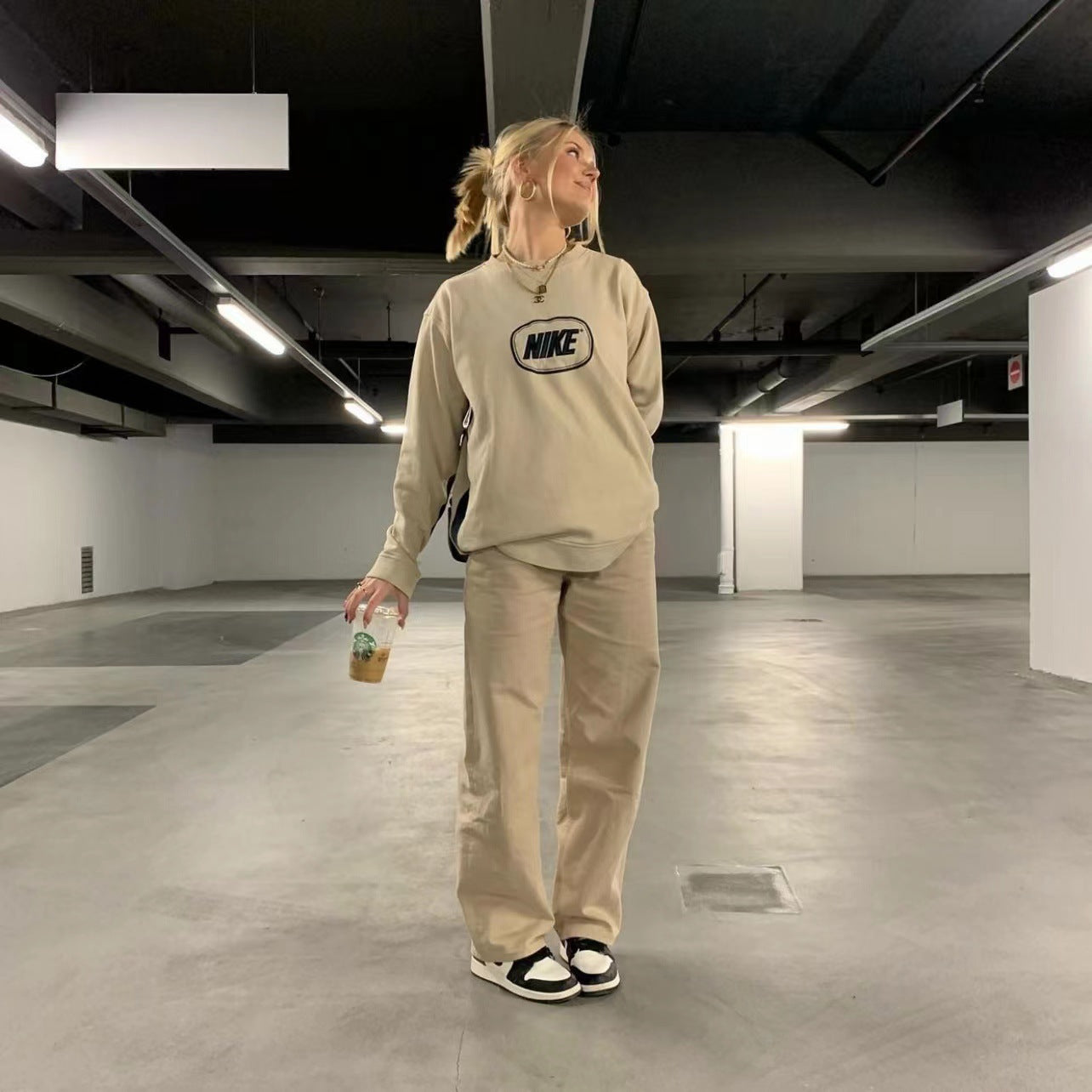 Woman in beige retro light khaki high waist draggle tail straight trousers, stylish fashion apparel