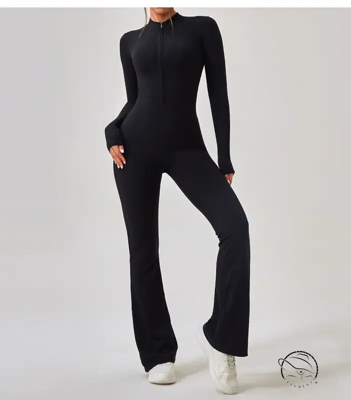 Black long-sleeved zip-up one piece sportswear jumpsuit with flared legs and white sneakers