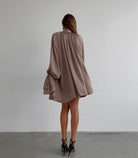 Flowy mauve satin dress featuring billowing long sleeves and gathered back design
