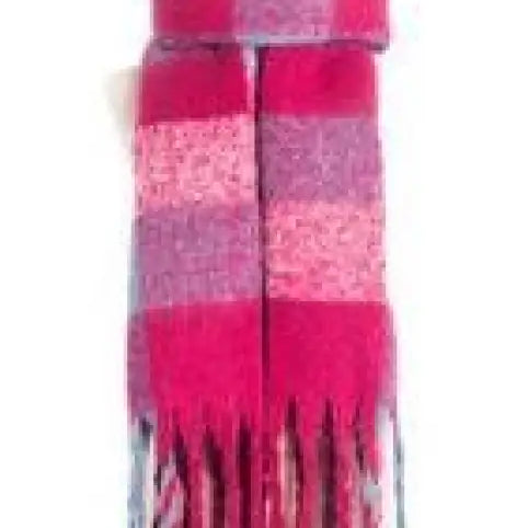 Pink and purple striped candle with dripping wax effect near purplish red wool stitching scarf