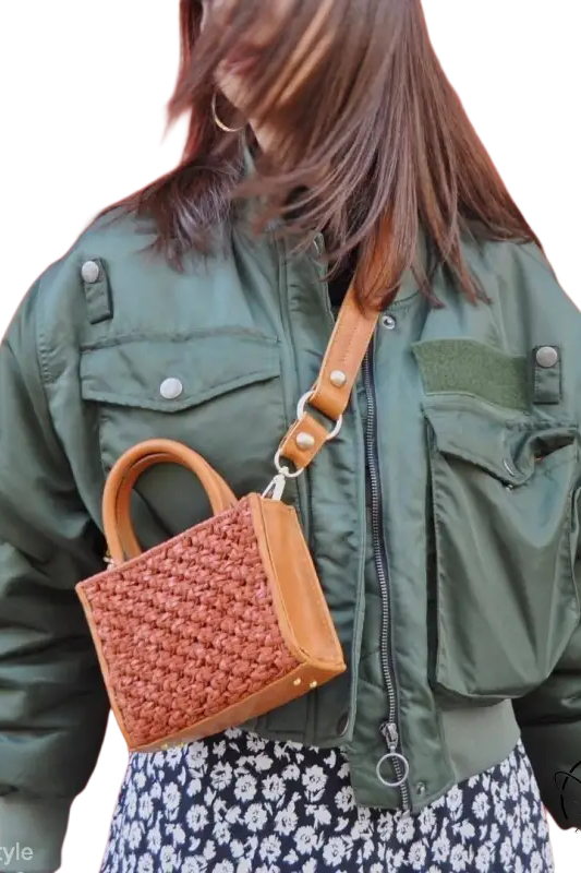 Army green thickened cotton padded bomber jacket over floral dress with woven handbag