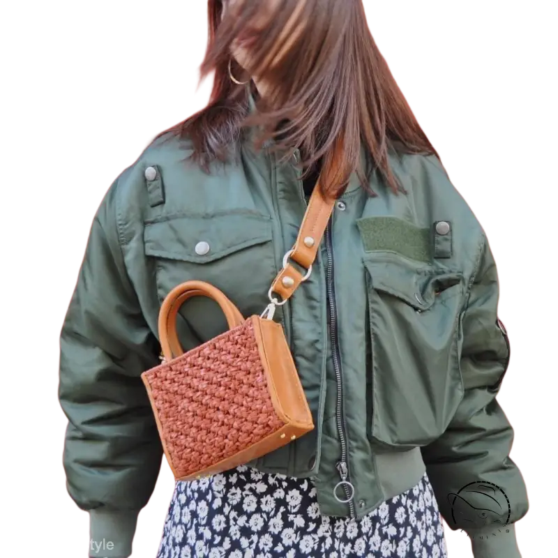 Army green thickened cotton padded bomber jacket over floral dress with woven handbag