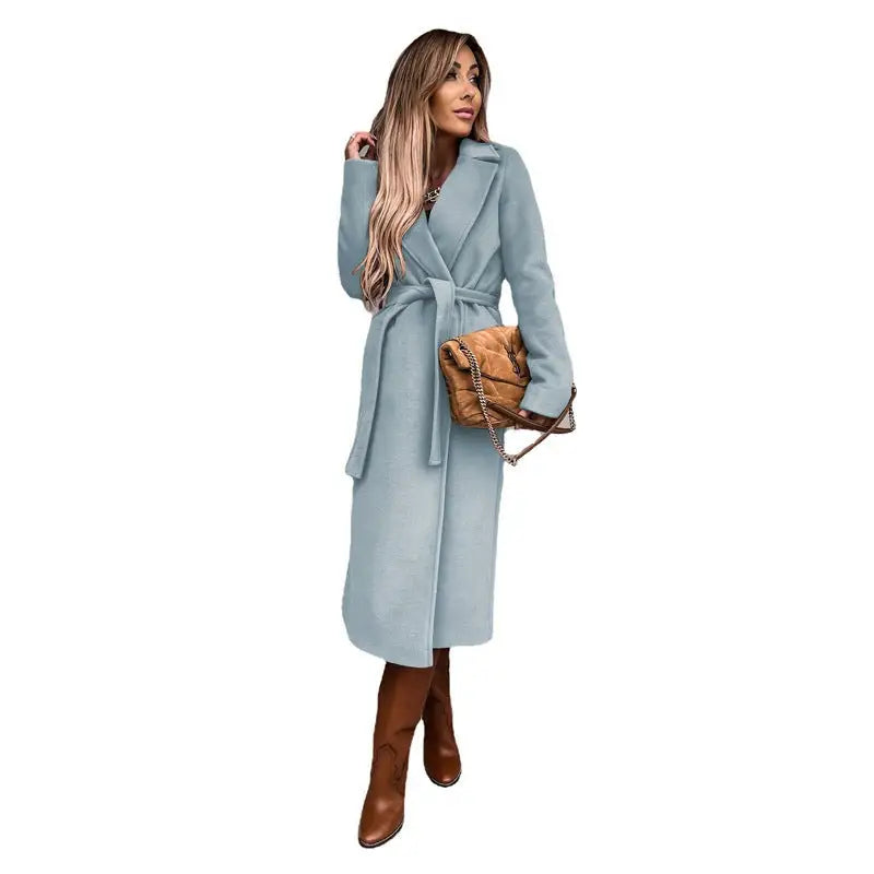 Long sleeved woolen coat in pale blue styled with brown leather boots and tan handbag