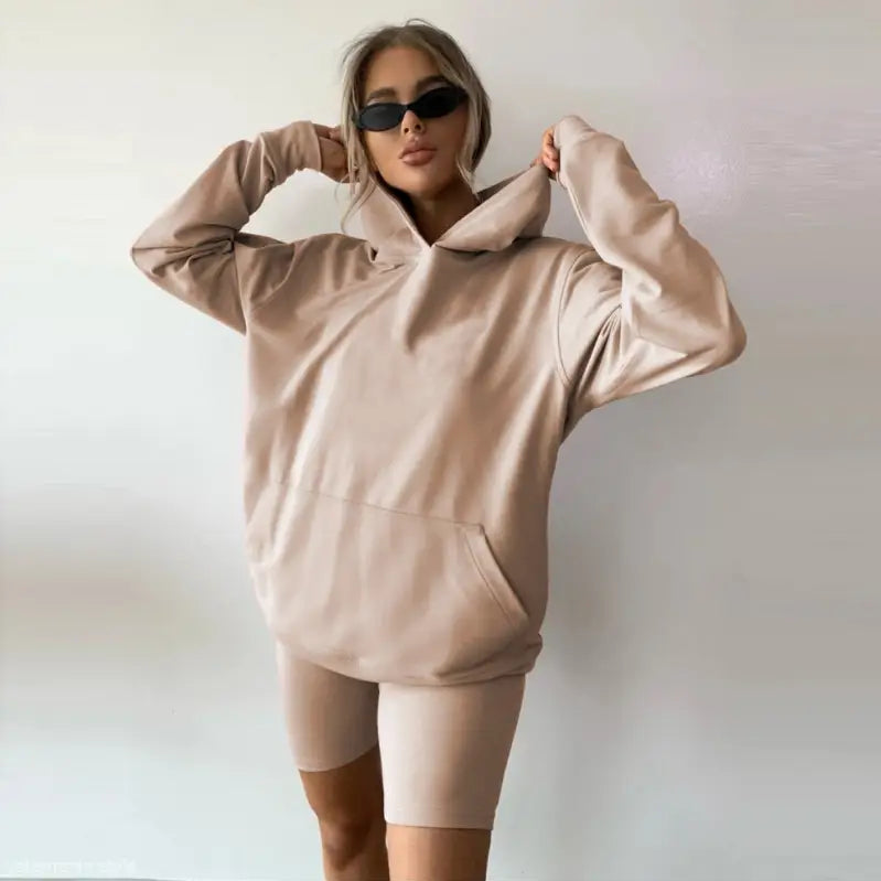 Woman wearing a beige oversized hoodie and bike shorts from the Comfy Sports Sweater Suit