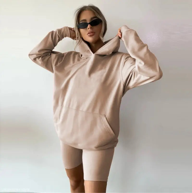 Woman wearing a beige oversized hoodie and bike shorts from the Comfy Sports Sweater Suit
