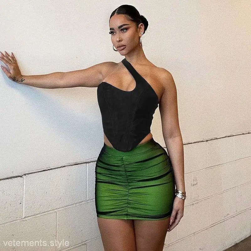 Woman in black top and green skirt showcasing the stylish shoulder vest boning corset