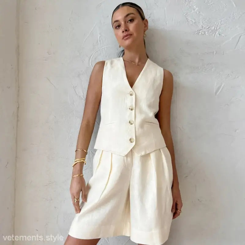 Woman wearing beige cotton suit with linen sleeveless top and shorts for casual office wear