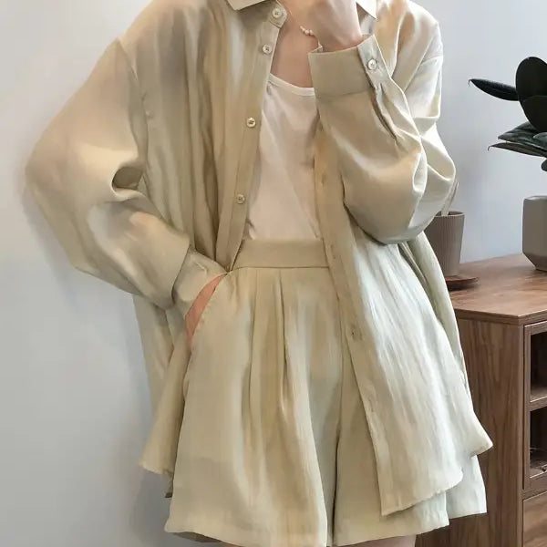 Cream-colored breathable sun protection outfit with a loose button-up shirt and pleated shorts