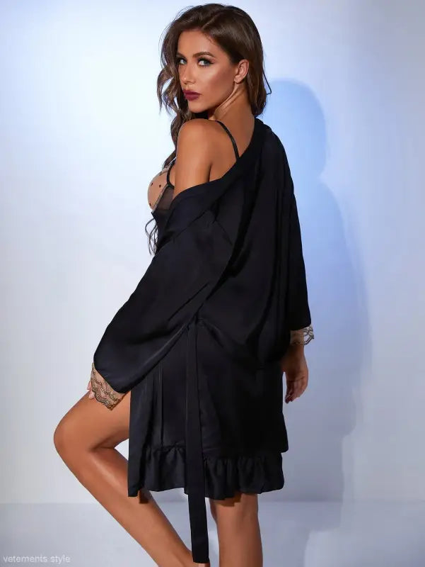 Woman in black lingerie and robe showcasing the Black Satin Midi Dress with Belted Sleeve