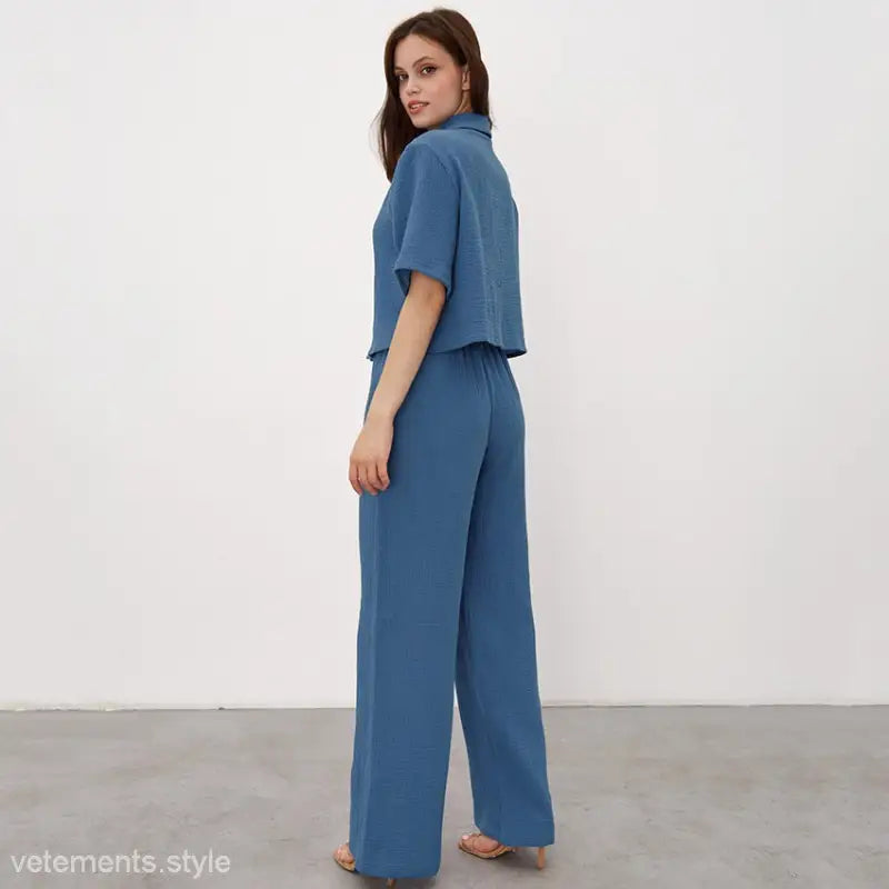 Woman in blue cotton pajamas set featuring a short-sleeved top and wide-leg pants