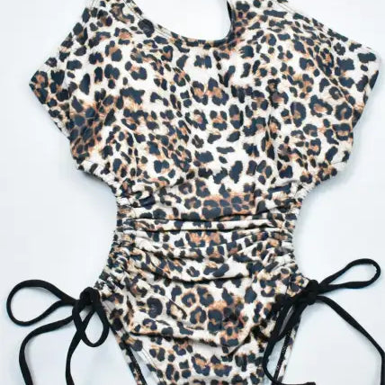 Leopard print one-piece bikini with black straps and side ties, perfect for boho beach style