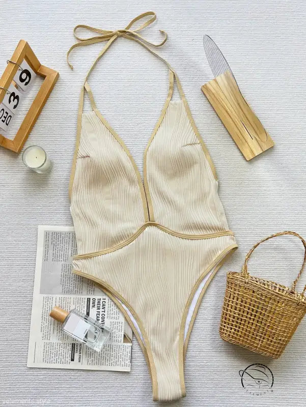 Cream-colored halter-neck coffee contrast swimsuit with gold trim