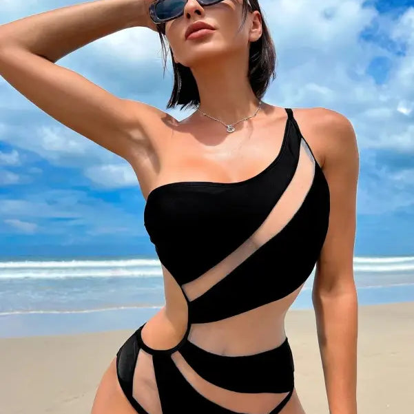 Woman in a black boho color block cutout piece swimsuit with sheer panels, free shipping available
