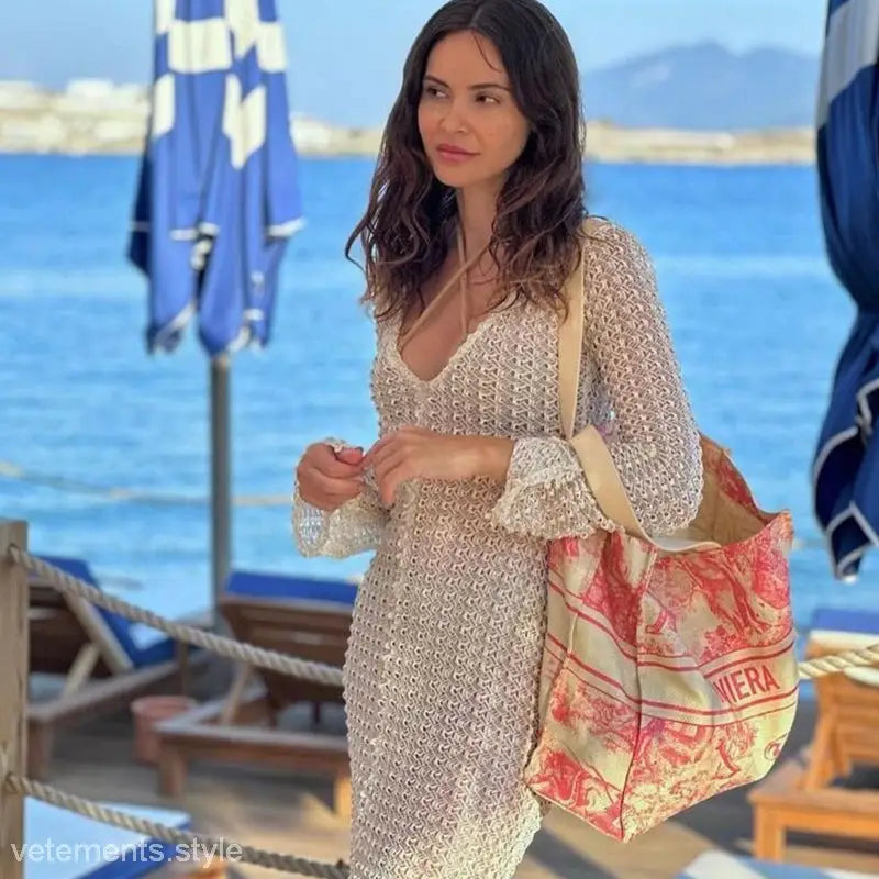 Woman in a crocheted dress with a tote bag for a stylish summer beach dress look