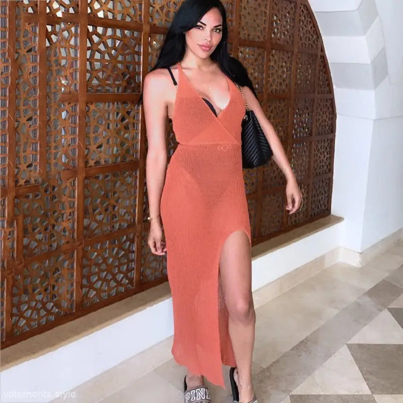 Woman in coral Boho Maxi Beach Strap Dress with thigh-high slit, perfect for vacation