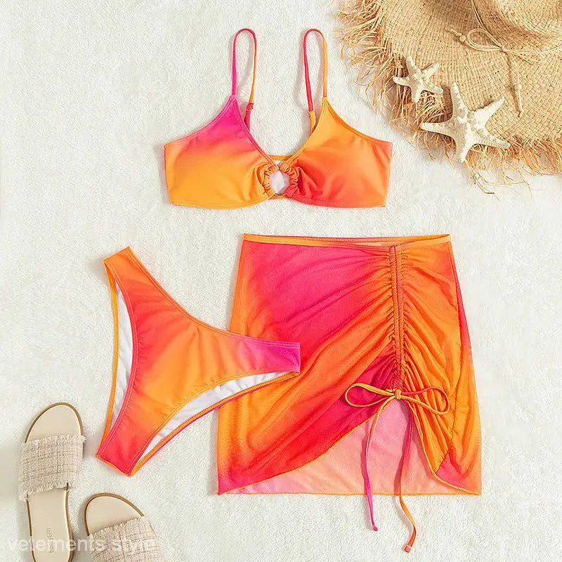 Ombre pink and orange three piece swimsuit with ring-front top, high-waisted bottoms, and ruched mini skirt